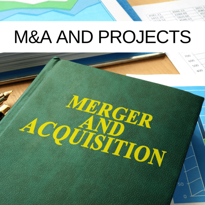 A green book that says Merger and Acquisition on it, laid on top of a desk